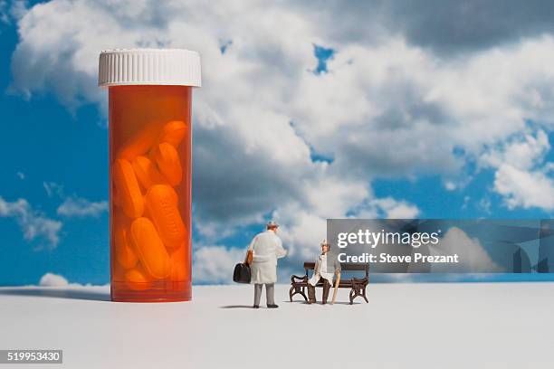 miniatures beside a pill bottle - figurines stock-fotos und bilder