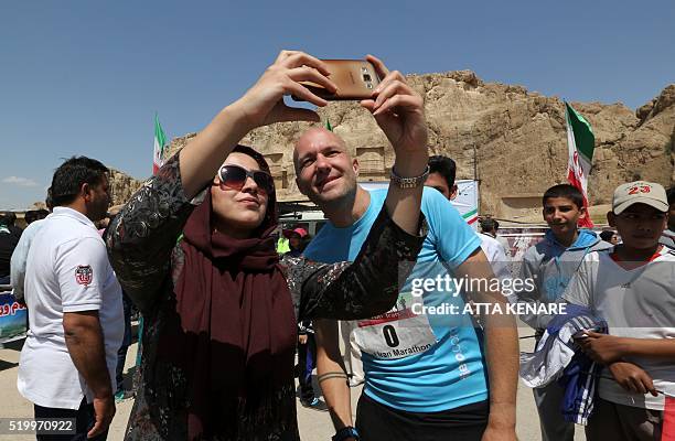 An Iranian woman poses for a selfie with Lithuanian competitor Jeffrey Parazzo at the finish line of Iran's first internation marathon in Marvdasht...