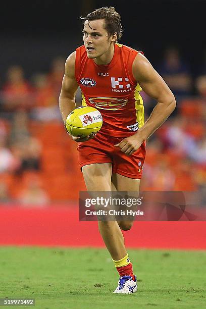 Kade Kolodjashnij of the Suns runs the ball during the round three AFL match between the Gold Coast Suns and the Carlton Blues at Metricon Stadium on...