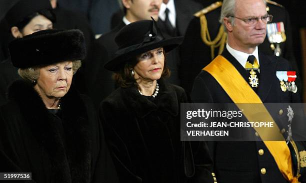 Queen Beatrix of the Netherlands, Queen Silvia and King Carl XVI Gustaf of Sweden stand as they listen to a sermon during the funeral of Luxembourg...