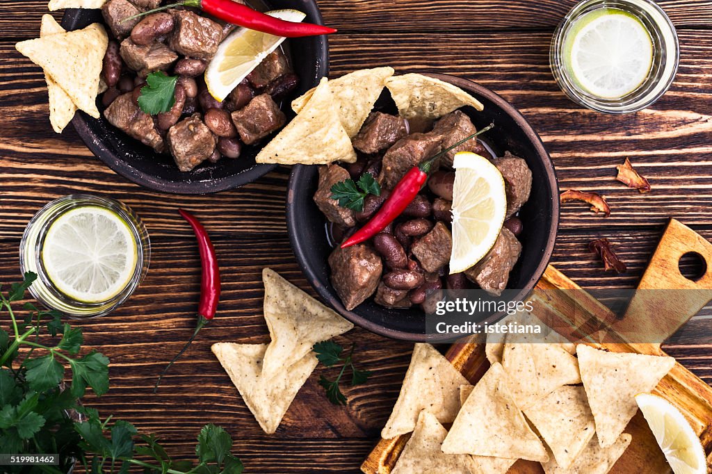 Beef and black bean chili served with corn tortilla chips viewed from above
