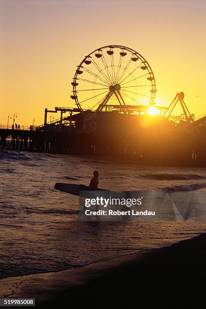 surfer near santa monica pier - santa monica stock-fotos und bilder