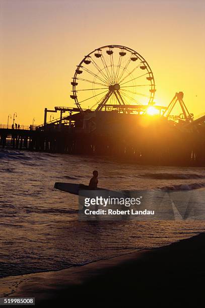 surfer near santa monica pier - california sunset stock pictures, royalty-free photos & images