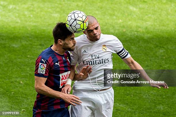 Pepe of Real Madrid CF wins the header before Adrian Gonzalez of SD Eibar during the La Liga match between Real Madrid CF and SD Eibar at Estadio...
