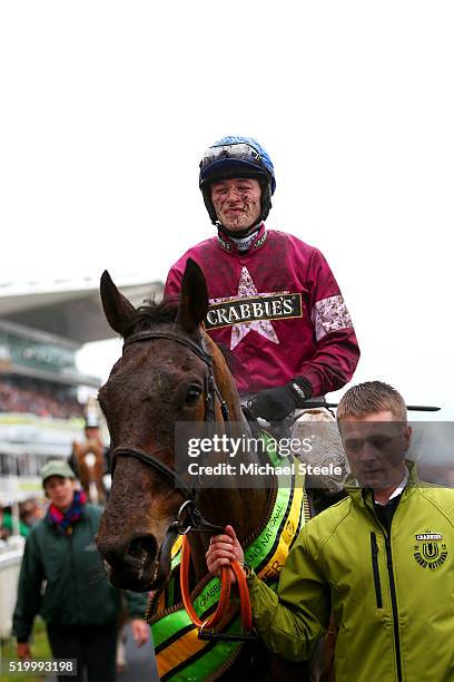 David Mullins celebrates as he enters the Winners' Enclosure after riding Rule The World to victory in the 2016 Crabbie's Grand National at Aintree...