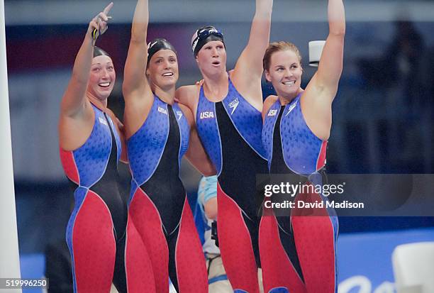 Amy Van Dyken, Dara Torres, Courtney Shealy, and Jenny Thompson of the USA women's 4x100 meter freestyle swimming relay team celebrate their win and...