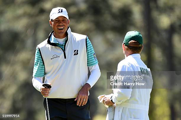 Matt Kuchar of the United States and caddie John Wood react to his birdie on the third hole during the third round of the 2016 Masters Tournament at...