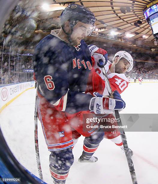 Dylan McIlrath of the New York Rangers is checked by Henrik Zetterberg of the Detroit Red Wings during the first period at Madison Square Garden on...