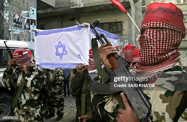 Palestinian militants of the Popular Front for the Liberation of Palestine carry a mock coffin wrapped with an Israeli flag in the southern Gaza...