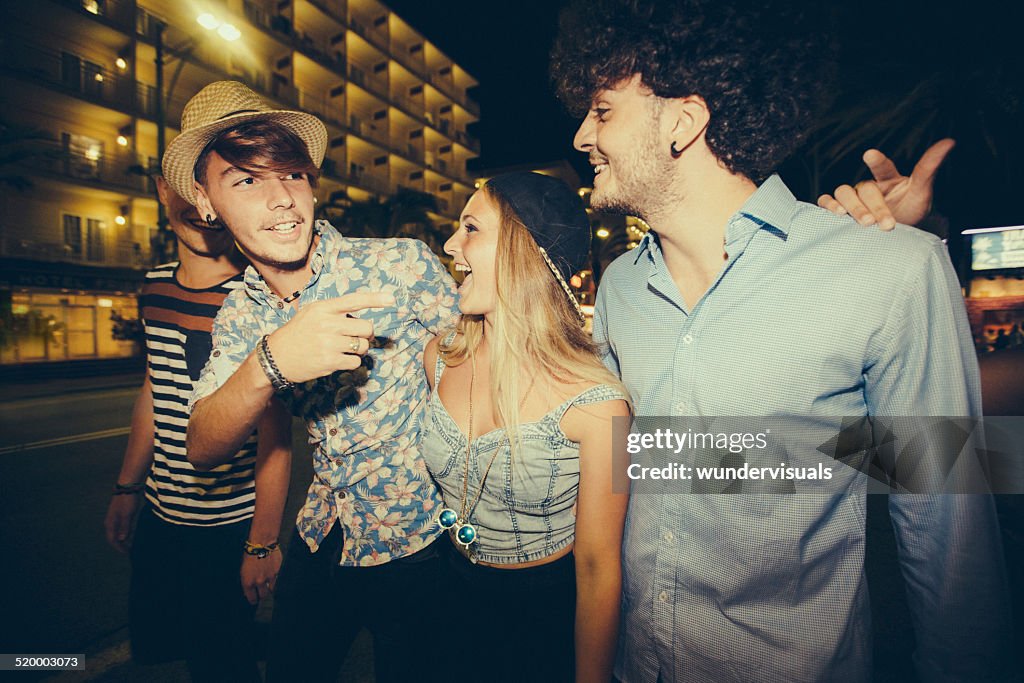 Hipster Friends Walking Together In Street At Night