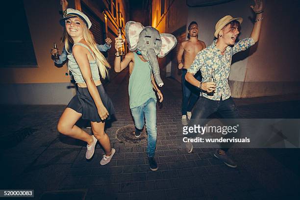 teenagers running down street during night party - costume party stock pictures, royalty-free photos & images