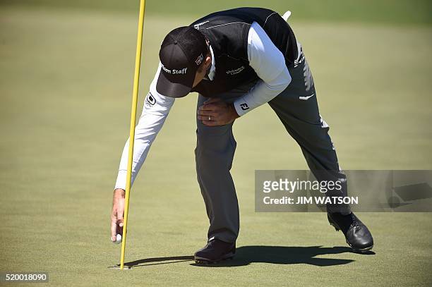 Golfer Kevin Streelman collects his ball on the 2nd green during Round 3 of the 80th Masters Golf Tournament at the Augusta National Golf Club on...