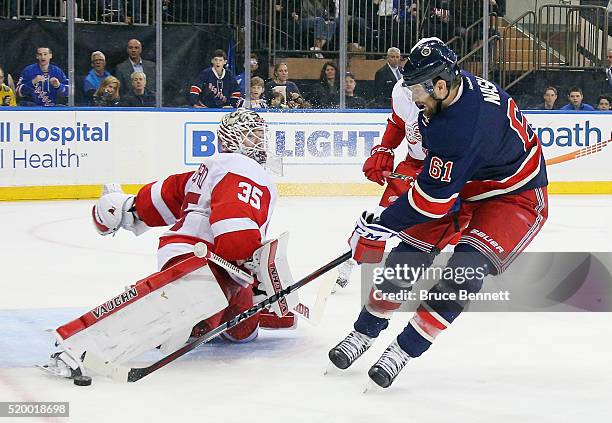 Jimmy Howard of the Detroit Red Wings makes the second period save against Rick Nash of the New York Rangers at Madison Square Garden on April 9,...