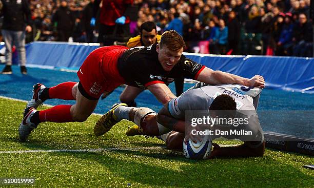 Courtney Lawes of Northampton Saints dives over for a try under pressure from Chris Ashton of Saracens during the European Rugby Champions Cup...
