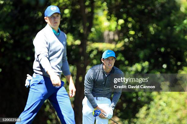 Rory McIlroy of Northern Ireland reacts to his shot from the second tee as Jordan Spieth of the United States walks from the tee during the third...