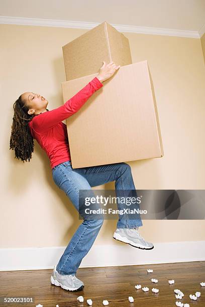 junge frau, die große kisten hebt - box lifting technique stock-fotos und bilder