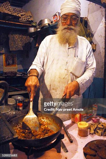 indian sikh man cooking chicken tikka masala - chicken tikka stock-fotos und bilder