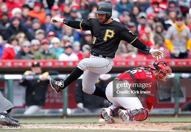 Francisco Cervelli of the Pittsburgh Pirates jumps past Tucker Barnhart of the Cincinnati Reds to score during the sixth inning at Great American...