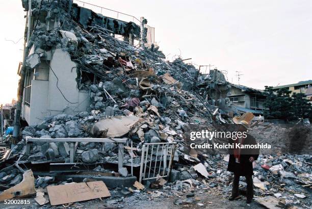 Japanese novelist Akiyuki Nosaka who was born in Kobe inspects destroyed buildings after the massive earthquake in that killed more than 6400 people...