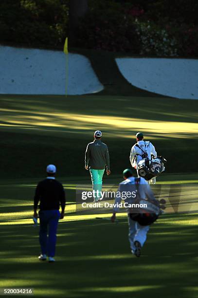 Dustin Johnson of the United States, caddie Austin Johnson, Danny Lee of New Zealand and caddie Mike Hartford walk on the 13th hole during the third...