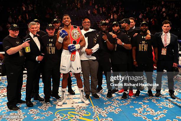 Anthony Joshua of England celebrates with the belt and his team after defeating Charles Martin of the United States in action during the IBF World...