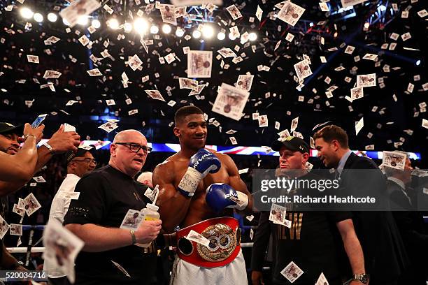 Anthony Joshua of England celebrates with the belt and his team after defeating Charles Martin of the United States in action during the IBF World...