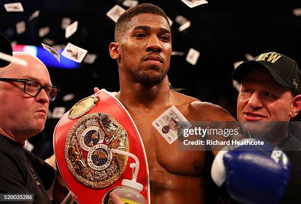 Anthony Joshua of England celebrates with the belt and his team after defeating Charles Martin of the United States in action during the IBF World...