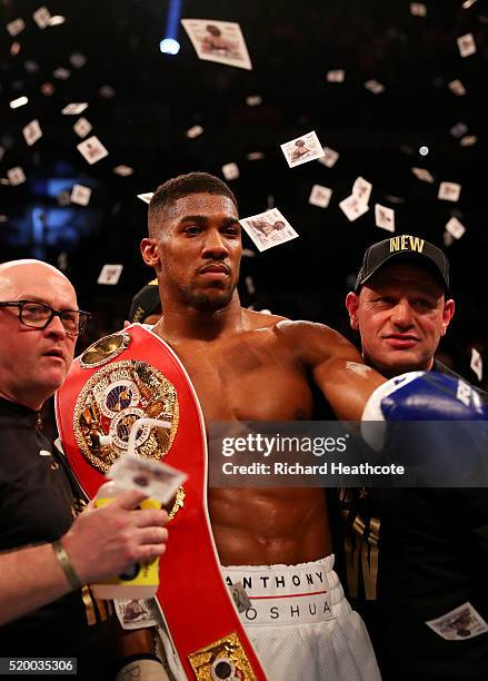 Anthony Joshua of England celebrates with the belt and his team after defeating Charles Martin of the United States in action during the IBF World...