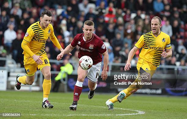 Sam Hoskins of Northampton Town moves forward with the ball between Ollie Clarke and Mark McChrystal of Bristol Rovers during the Sky Bet League Two...