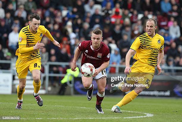 Sam Hoskins of Northampton Town moves forward with the ball between Ollie Clarke and Mark McChrystal of Bristol Rovers during the Sky Bet League Two...