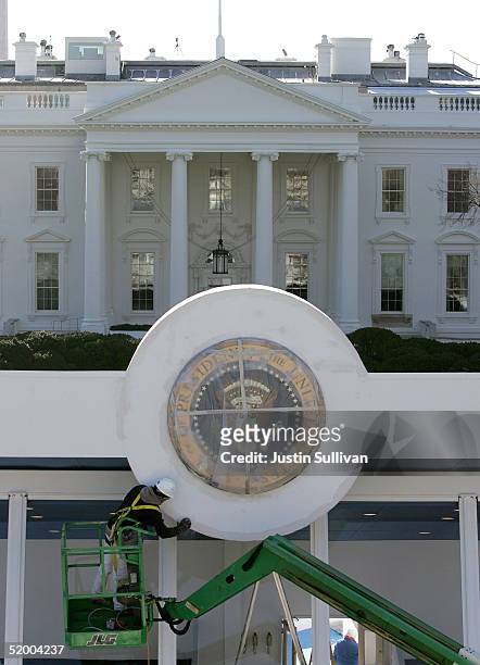 Worker sands the presidential seal on the Inaugural Parade viewing stand in front of The White House January 17, 2005 in Washington, DC. U.S....