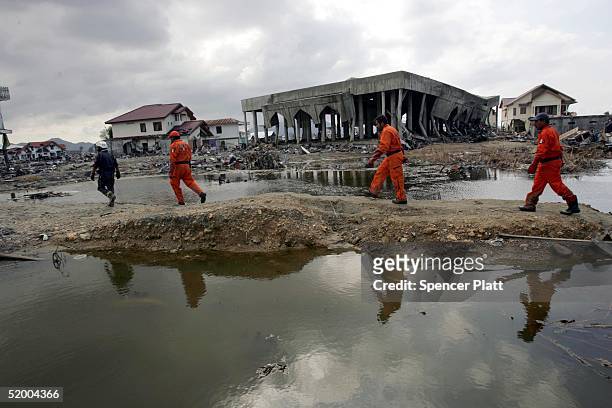 Members of Mexican and German search and rescue teams look for bodies amongst the rubble of destroyed homes January 14, 2005 in Banda Aceh,...