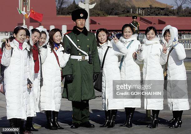 Group of Chinese girls gather to pose for a picture with a paramilitary policeman guarding the flag podium on Tiananmen Square in Beijing, 18 January...