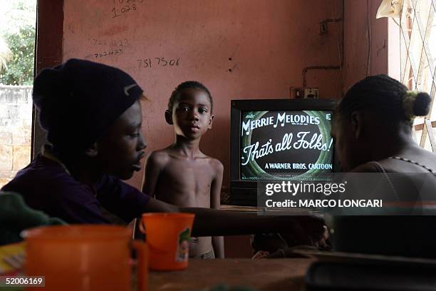 Members of the Onesime family watch television in the house they share with 26 other family members in Port Louis, Mauritius, 17 January 2005. The...