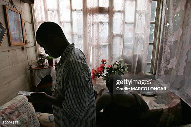 Louise Auguste sits at her table, 17 January 2005 at her home in Port Louis, Mauritius. The family of 9, originally from the Chagos Archipelago now...
