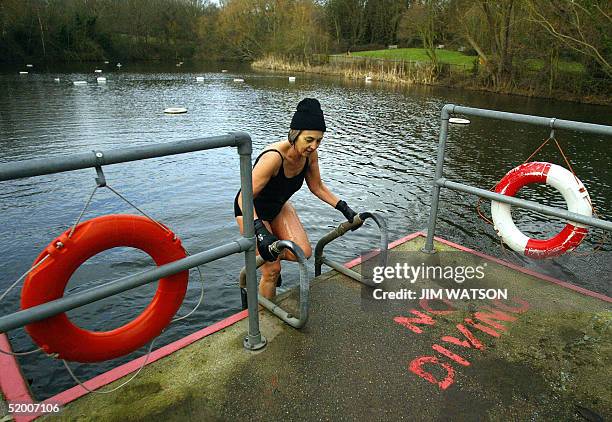 Wearing gloves and a wool cap, Sarah Saunders exits the Women's Bathing Pond on Hampstead Heath 18 January, 2005 in London after a brisk afternoon...