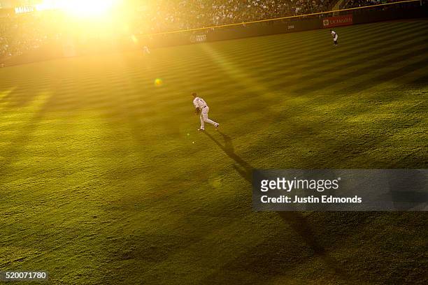 The evening sun glows as right fielder Carlos Gonzalez of the Colorado Rockies prepares for the pitch during the third inning against the San Diego...