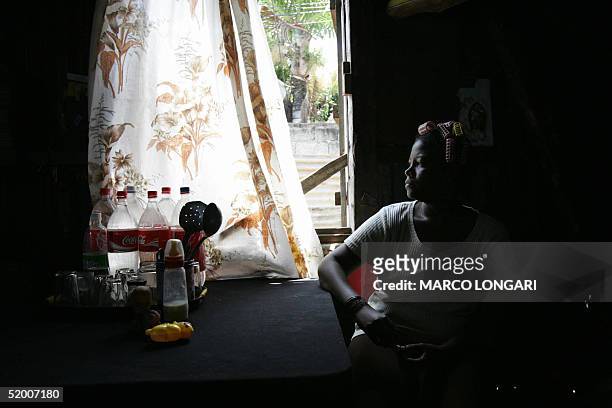 Member of the Onesime family sits in the kitchen of the house she shares with 26 other family members in Port Louis, Mauritius, 17 January 2005. The...