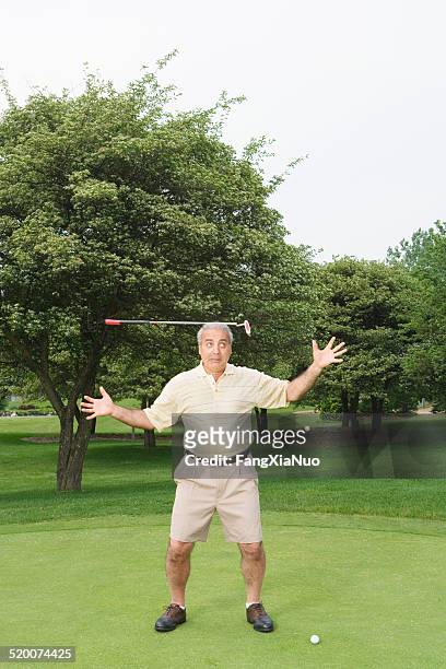 men balancing golf club on head - golf short iron stock pictures, royalty-free photos & images