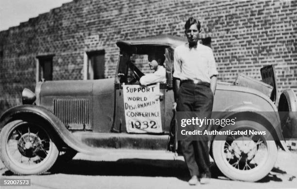 An American Friends Service Committee team of two young men with their car, loaned from the AFSC, on which they have hung a sign that says, "Support...