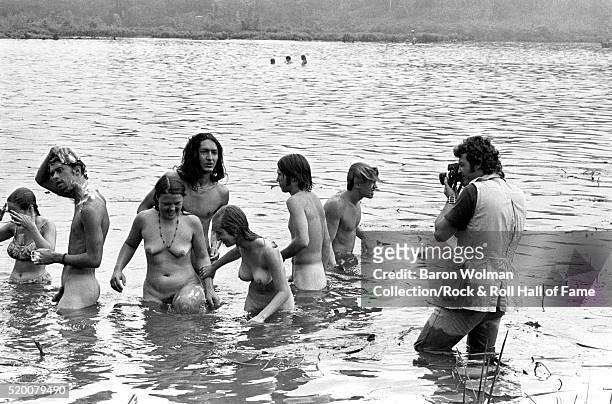 Photographer photographs a group of people swimming naked in the lake at the Woodstock Music & Art Fair, Bethel, NY, August 15, 1969.