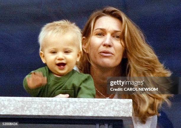 Steffi Graf holds her son Jaden Gil as they watch husband and father Andre Agassi's match against Justin Gimelstob 29 August, 2002 at the US Open in...