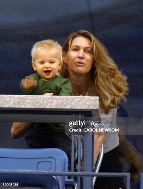 Steffi Graf holds her son Jaden Gil as they watch husband and father Andre Agassi's match against Justin Gimelstob 29 August, 2002 at the US Open in...
