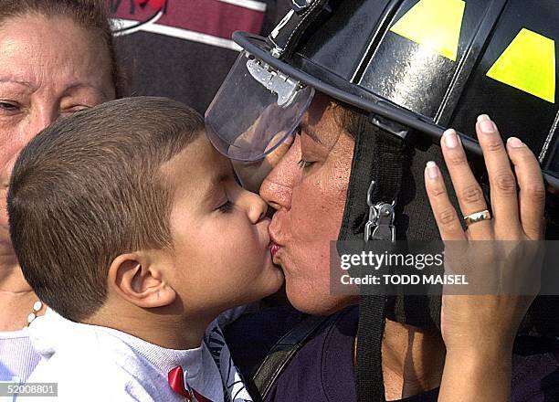 Joviana Mercado kisses her youngest son Austin as they attend World Trade Center memorial ceremony 11 September to remember husband and father...