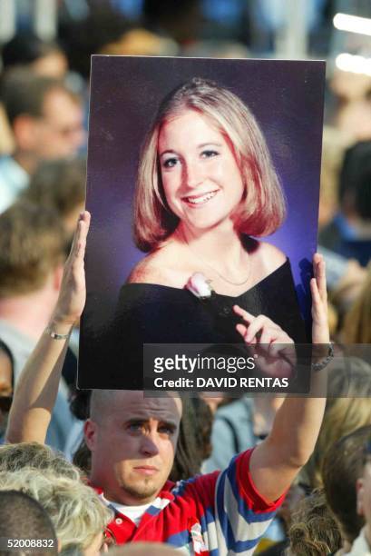Man holds aloft a portrait of a lost loved one during a ceremony 11 September 2002 in New York marking the one year anniversary of the deadly...