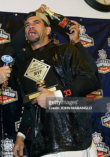 Benito Santiago of the San Francisco Giants holds the MVP trophy in the locker room after clinching the National League Championship against the St....