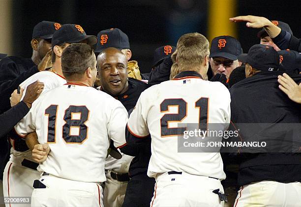 Barry Bonds of the San Francisco Giants is surrounded by teammates after clinching the National League Championship against the St. Louis Cardinals...