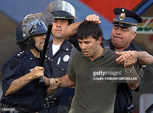 Anti-riot police arrest a soccer fan after the game in Buenos Aires, Argentina 01 December 2002. Un simpatizante de San Lorenzo es detenido tras...