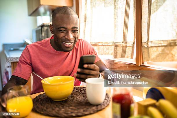 african guy doing breakfast at home - new morning stock pictures, royalty-free photos & images