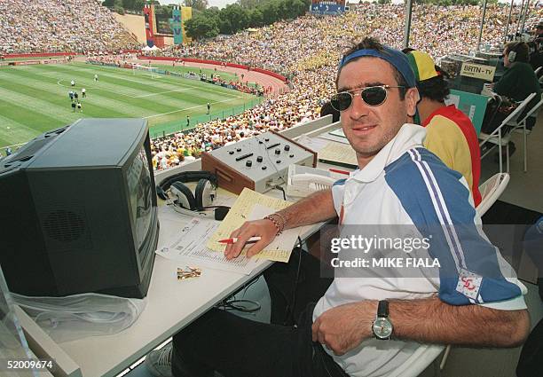 French soccer star and television sportscaster Eric Cantona poses in his broadcast booth prior to the start of the Brazil/Cameroon World Cup match 24...